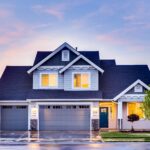 من نحن 22 Beautiful two-story house with illuminated windows and garage at dusk.