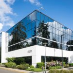 من نحن 20 Contemporary office building in Redmond with reflective glass and lush greenery, captured on a sunny day.